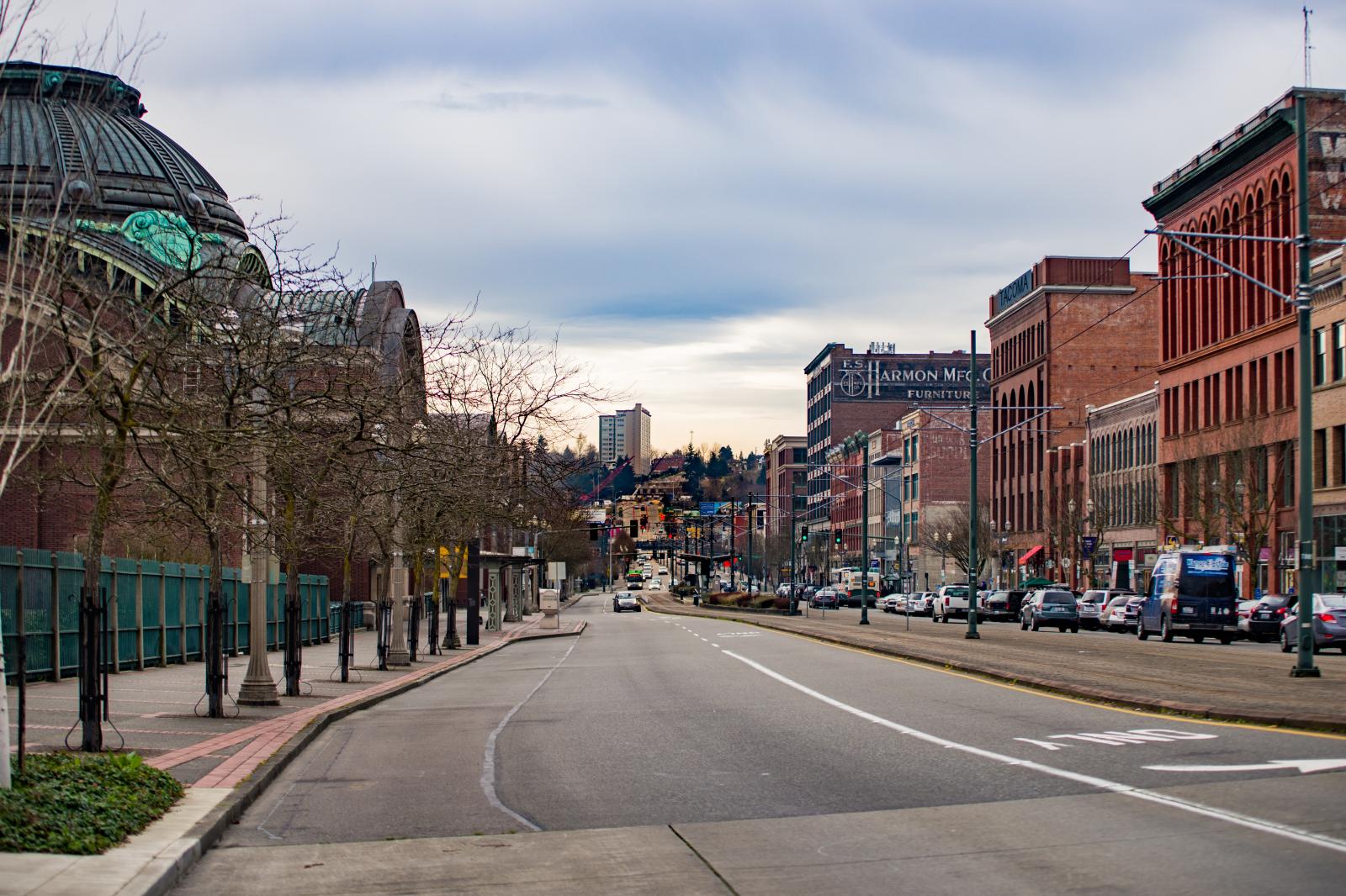 A color photo looking south down Pacific Avenue, taking in a large brick building with a weathered copper dome. The building is the Union Station Depot. Historic brick buildings line the other side of the street.