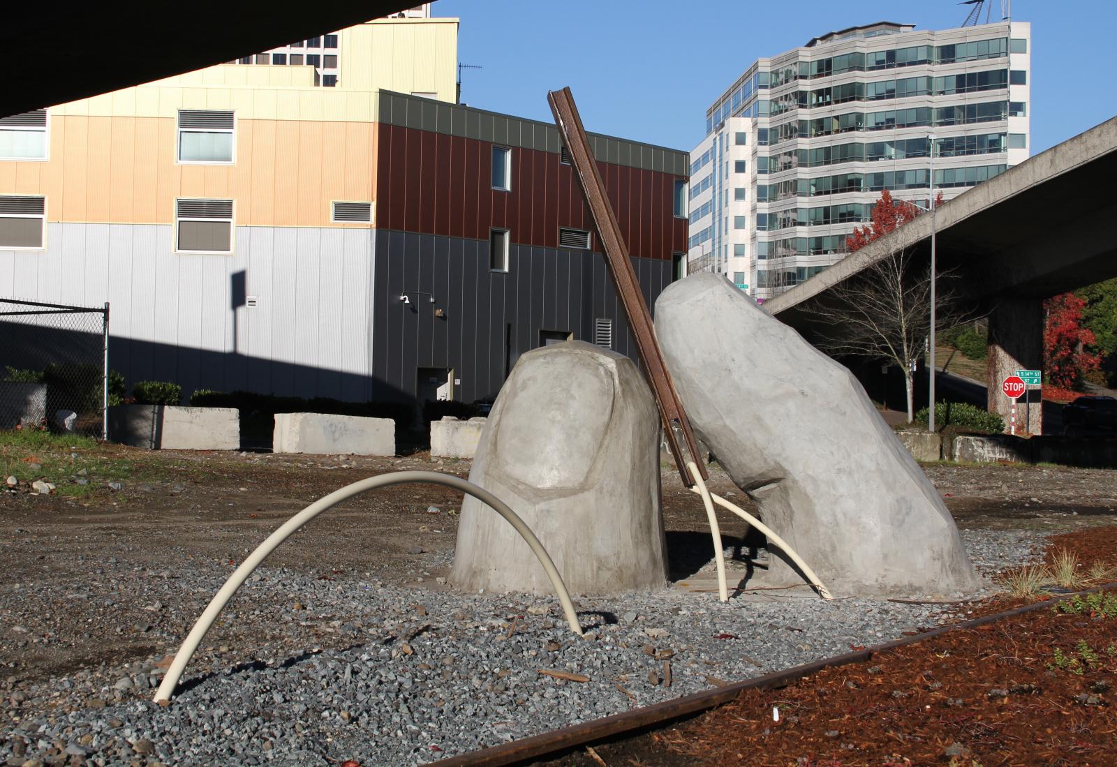 The completed art piece, a sculpture of a thumb and forefinger holding a needle made of repurposed steel rail