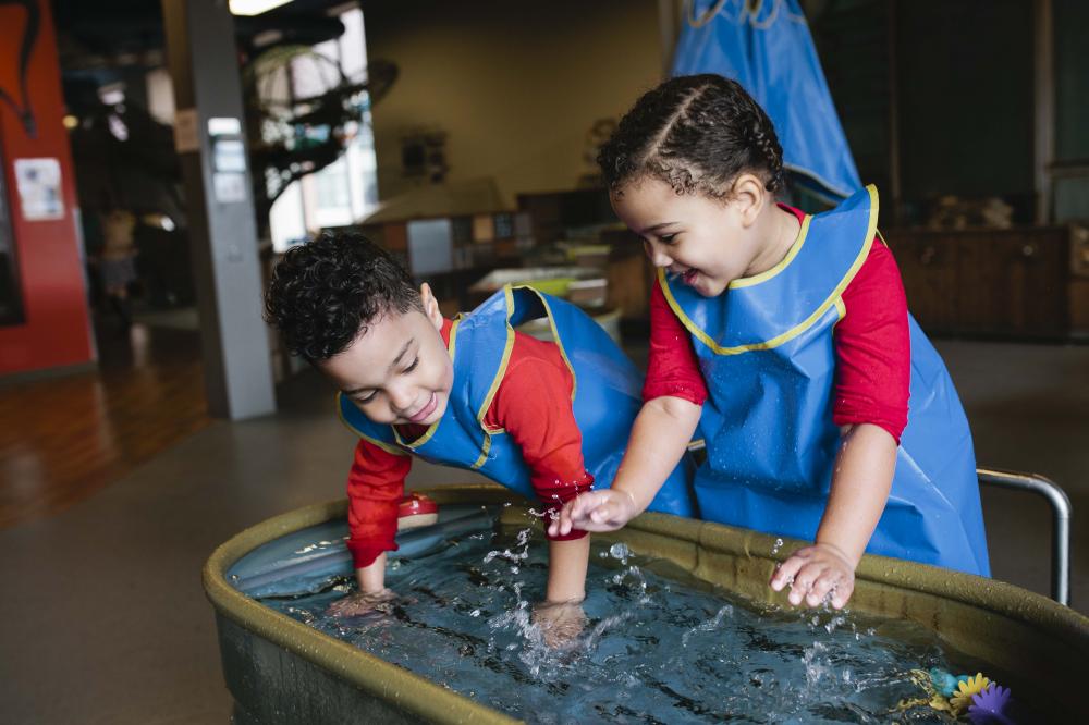 Two children at play in the water inside the Childrens Museum exhibits.